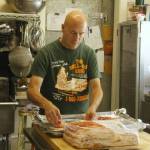 Photo by Kira Erickson/South Whidbey Record
Sean McArthur transfers some bacon onto a baking sheet in the kitchen of Whidbey Doughnuts, a beloved restaurant popular for its pastries, breakfast and lunch that is closing after Labor Day.