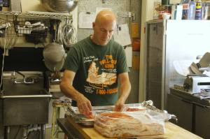 Photo by Kira Erickson/South Whidbey Record
Sean McArthur transfers some bacon onto a baking sheet in the kitchen of Whidbey Doughnuts, a beloved restaurant popular for its pastries, breakfast and lunch that is closing after Labor Day.