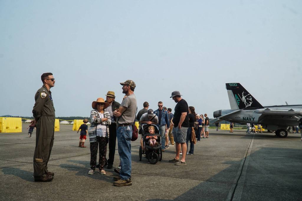Lt. Justin Goode answers questions as guests wait to board a P-3 Orion at Naval Air Station Whidbey Island on Saturday. (Photo by Sam Fletcher)