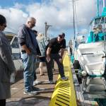 Harbor Master Chris Sublet (right) discusses the shape of the dock cleats and the recent electrical upgrades with City Administrator Sabrina Combs (left) and Councilmember Jim Woessner (middle) Thursday morning. (Photo by Sam Fletcher)
