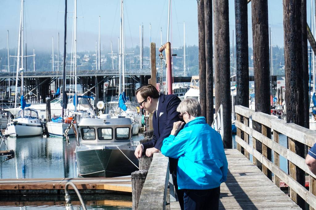 Councilmembers Bryan Stucky and Barbara Armes watch a seal chase a fish at the Oak Harbor Marina Thursday morning. (Photo by Sam Fletcher)