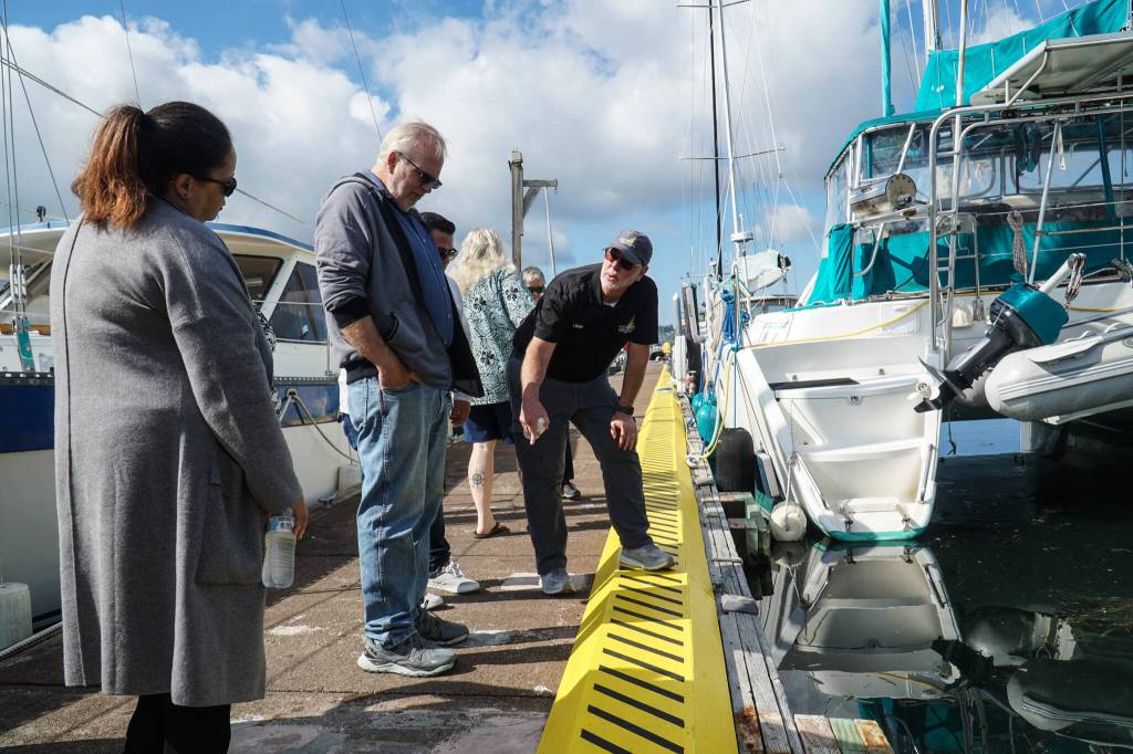 Photo by Sam Fletcher
Harbor Master Chris Sublet (right) discusses the shape of the dock cleats and the recent electrical upgrades with City Administrator Sabrina Combs (left) and Councilmember Jim Woessner (middle) Thursday morning.