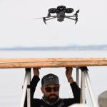 San Diego Zoo Alliance UAV pilot holds a landing pad while a drone lands after collecting breath samples. (Photo provided)