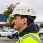 (Photo by Luisa Loi)
Derek proudly wears the helmet signed by the C Johnson Construction crew.