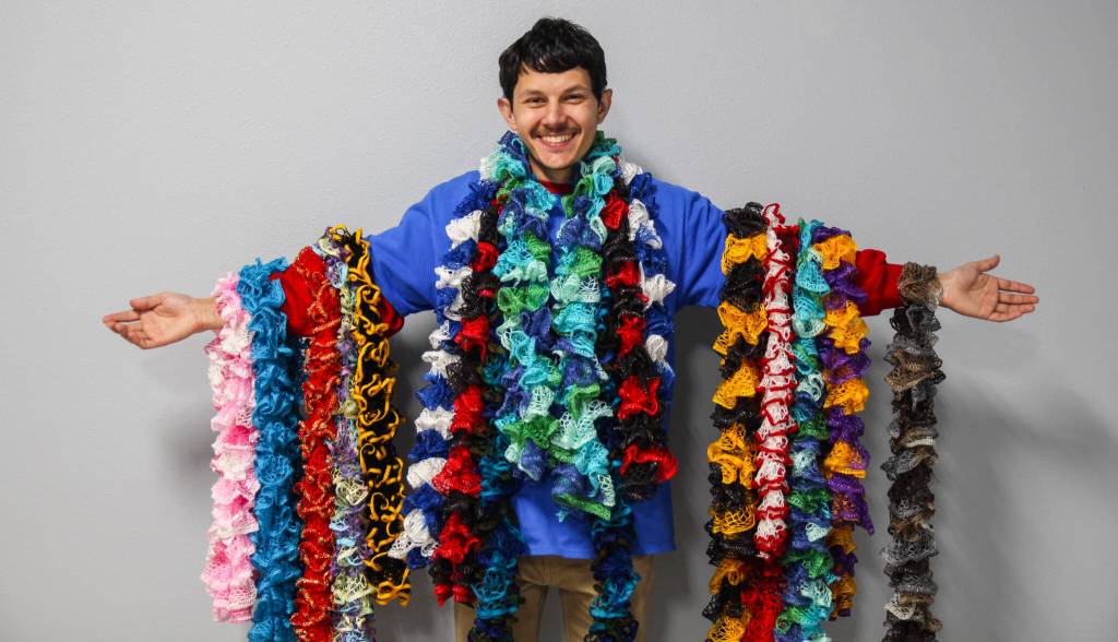 (Photo by Luisa Loi)
Roman Larsen proudly shows some of his handmade scarves. While it normally takes him a few days to finish one, he has been able to create scarves in less than an hour.