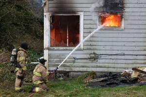 Firefighters from Oak Harbor, North Whidbey, South Whidbey and Naval Air Station Whidbey Island conduct live burn training in Oak Harbor last week. (Photo by John Fisken)