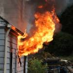Flames shoot out from the window of a house that was used in the live burn training. (Photo by John Fisken)
