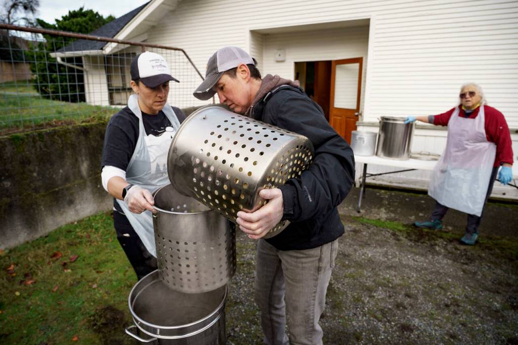 (Photo by David Welton)
Dakota and Lauren Stone pour potatoes into the propane-powered boiler.