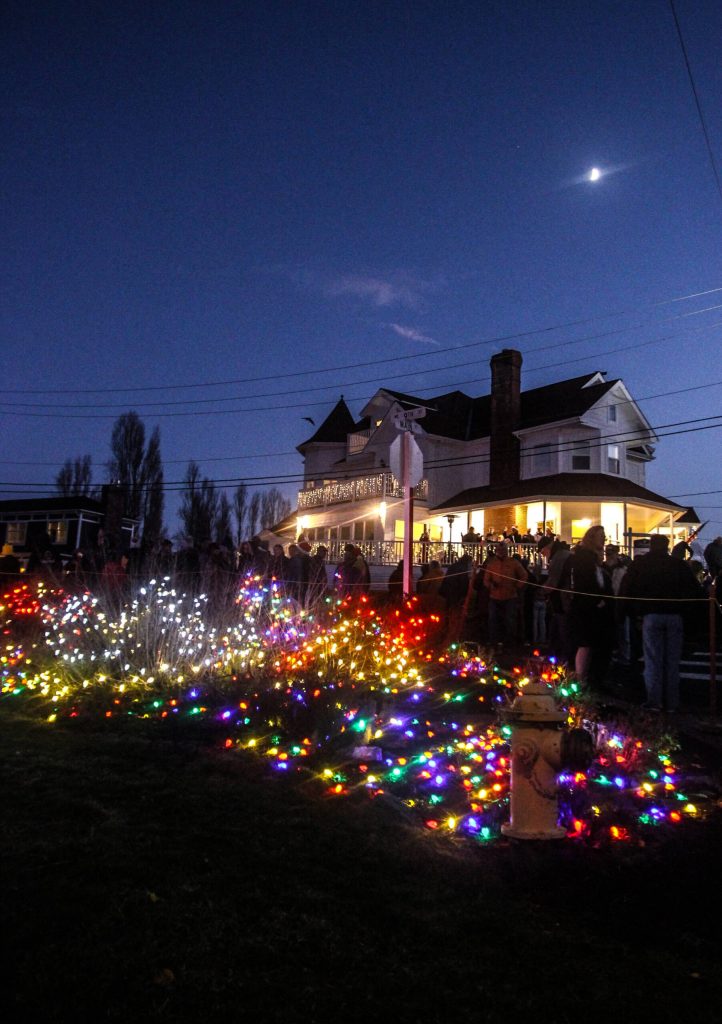 Photo by Luisa Loi
Coupevilles Cooks Corner Park sparkles in front of Anchorage Inn, where a group of carolers entertained a crowd of parade goers.