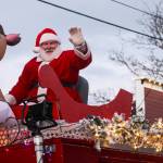On board the Central Whidbey Fire and Rescues truck, Santa Claus waves at the crowd that gathered on Coupevilles Front Street. (Photo by Luisa Loi)