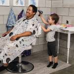 (Photo by Luisa Loi)
Jane Carter gives her mom, Maddie Evans, a haircut at Imagination Cove, a family center owned by two military spouses, Jaylynn Sybrant and Mala Sooknanan. The museum opened in July.