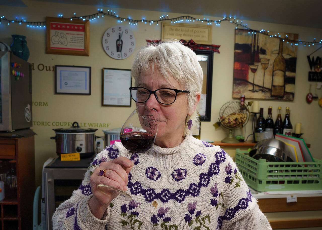 (Photo by David Welton)
Greenbank Farm Wine Shop employee Cathy Kind takes in the aroma of a loganberry wine.