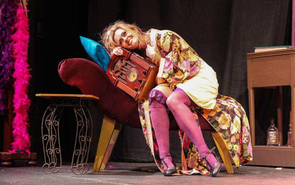 (Photo by Luisa Loi)
The forever single Miss Hannigan (Abby Thuet) listens to a romance radio show.