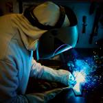 Photo by David Welton
Blue sparks fly as welder Jim Bernacki works on a piece of metal.