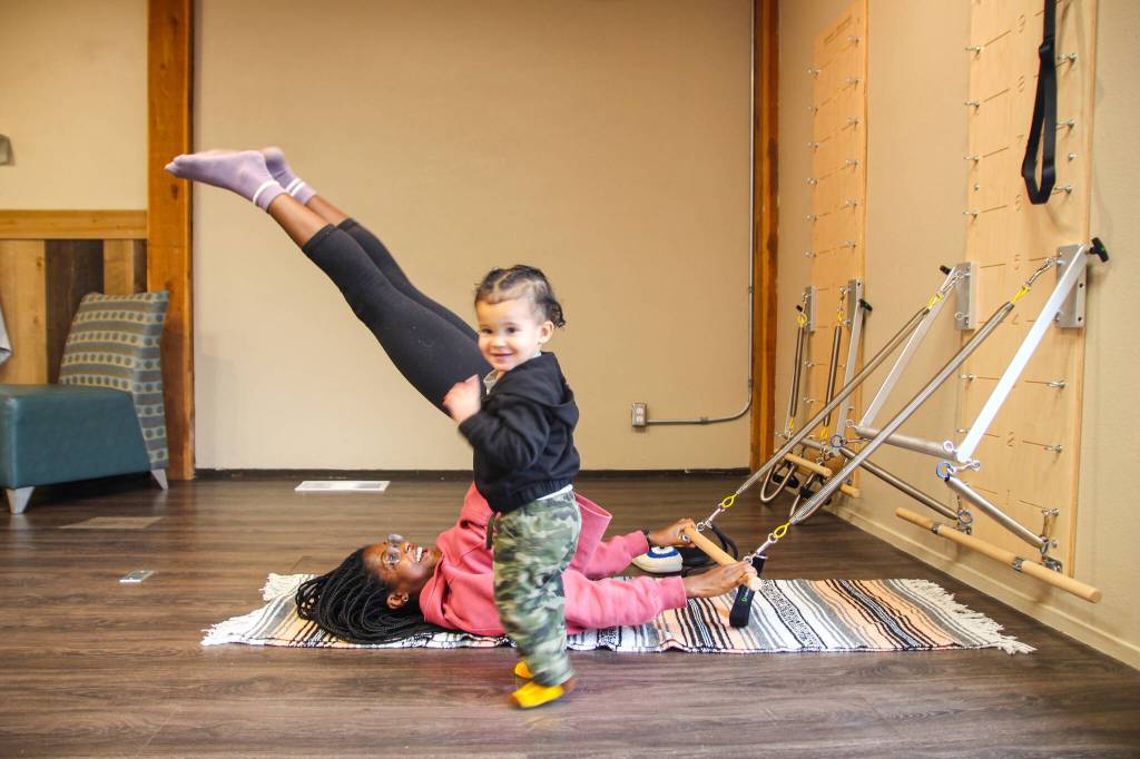 Photo by Luisa Loi
Shelby Novak stretches with the help of a spring board while her son Glenn provides emotional support.