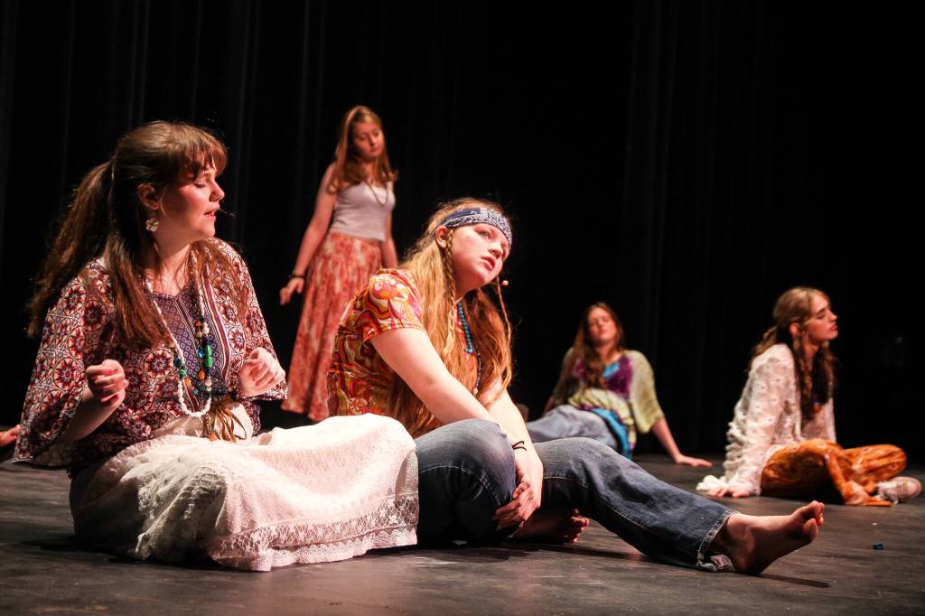 (Photo by Luisa Loi)
Two hippies, played by Piper Ehrhart and Sammi Fisher, gently sway to the sound of music while sitting on the muddy farmland where the Woodstock Music Festival took place in 1969. Director Eric George hopes the play will reignite the love for music from the 1960s.