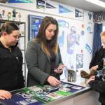 At left, Emily Lamb, Taylor Puckett and Hunter Meyer look at cards. (Photo by Luisa Loi)