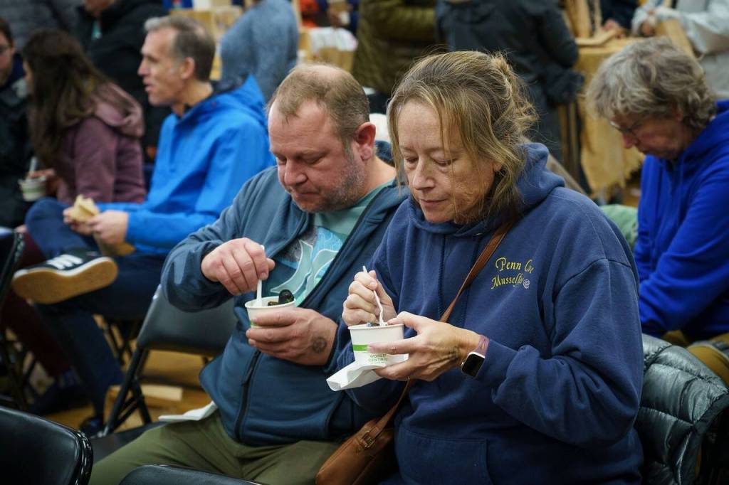 Audience members enjoy some mussels at the Coupeville Recreation Hall, away from the cold. Musselfest also featured the traditional chowder eating contest, which was won by Goldies and the Roost, followed by The Oyster Catcher and Captain Whidbey, according to Musselfest Chair Kellie Sites.