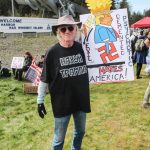 Jack Gribble, a disabled Coast Guard veteran, held a sign depicting Trump riding a swastika monowheel. (Photo by Luisa Loi)