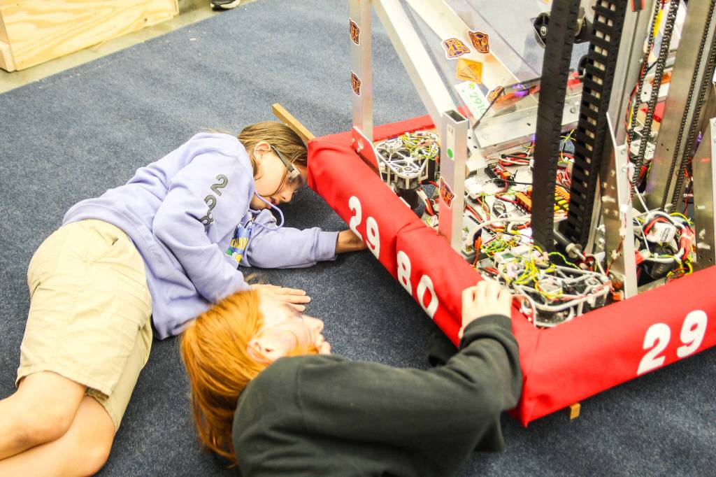 Oak Harbor Wildcat Thorin Allen and Coupeville Wolf Orion Liedtke get Evb0t ready for the world championship next week. After the competition and the off-season events, the robot will be taken apart so students can reuse its pieces, according to Mentor Alison Perera. (Photo by Luisa Loi)