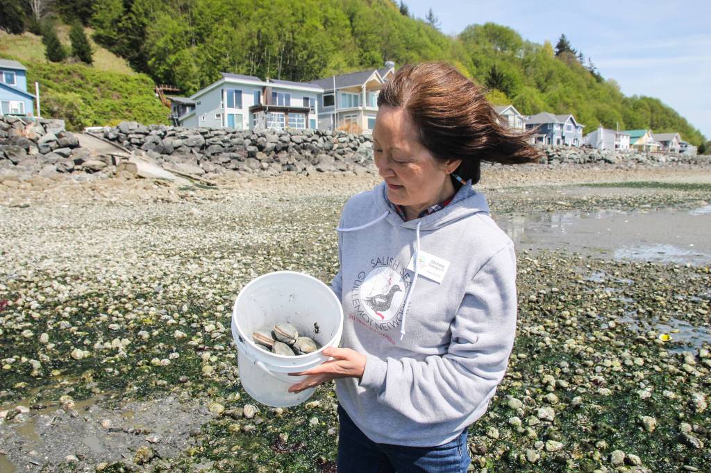 (Photo by Luisa Loi)
Michele Sakaguchi, a science and math teacher who graduated from Sound Water Stewards in 2022, holds a bucket of butter clams. Sakaguchi and her husband held the Digging 4 Dinner program for years until it was shut down due to shellfish bed closures.