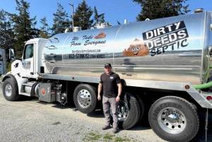 Photo by Harry Anderson
Keith Jordan stands beside his biggest septic pumping truck, which holds 5,000 gallon of stuff.