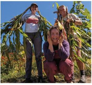 Photo provided 
Good Cheer Garden Co-leads Katherine Proulx and Carlee Bane harvest crops with a volunteer.