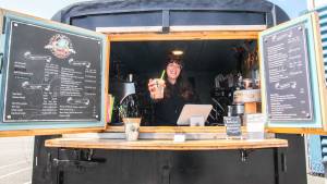 Koehler Stephens serves a drink from inside her coffee shop on wheels, Sons of Neptune Espresso.