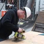Photo by Marina Blatt.
A student cuts a slab of wood to fit it into the wall.