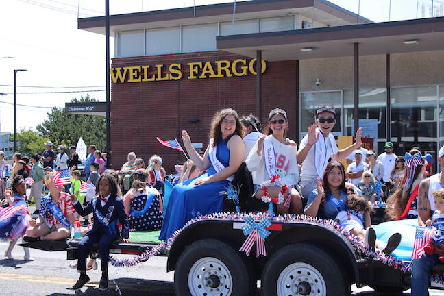Young men and women wave from their parade float (Photo by Allyson Ballard)