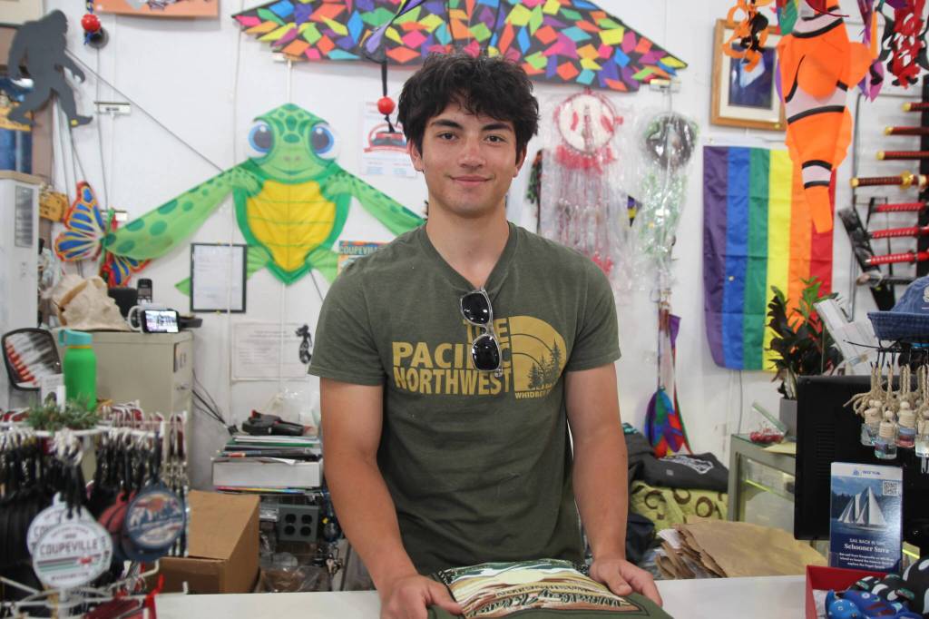 (Photo by Marina Blatt) Cashier Ryan Blouin folds a shirt at Harbor and Gift inside the wharf.