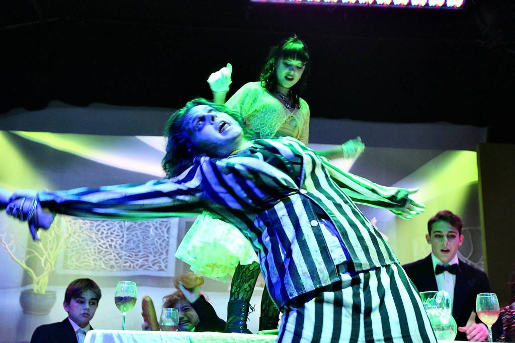 (Photo by Marina Blatt) Beetlejuice dances with glee during a chaotic dinner table scene.