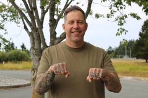 (Photo by Allyson Ballard) Command Master Chief Ben Faulise shows off his finger tattoos.