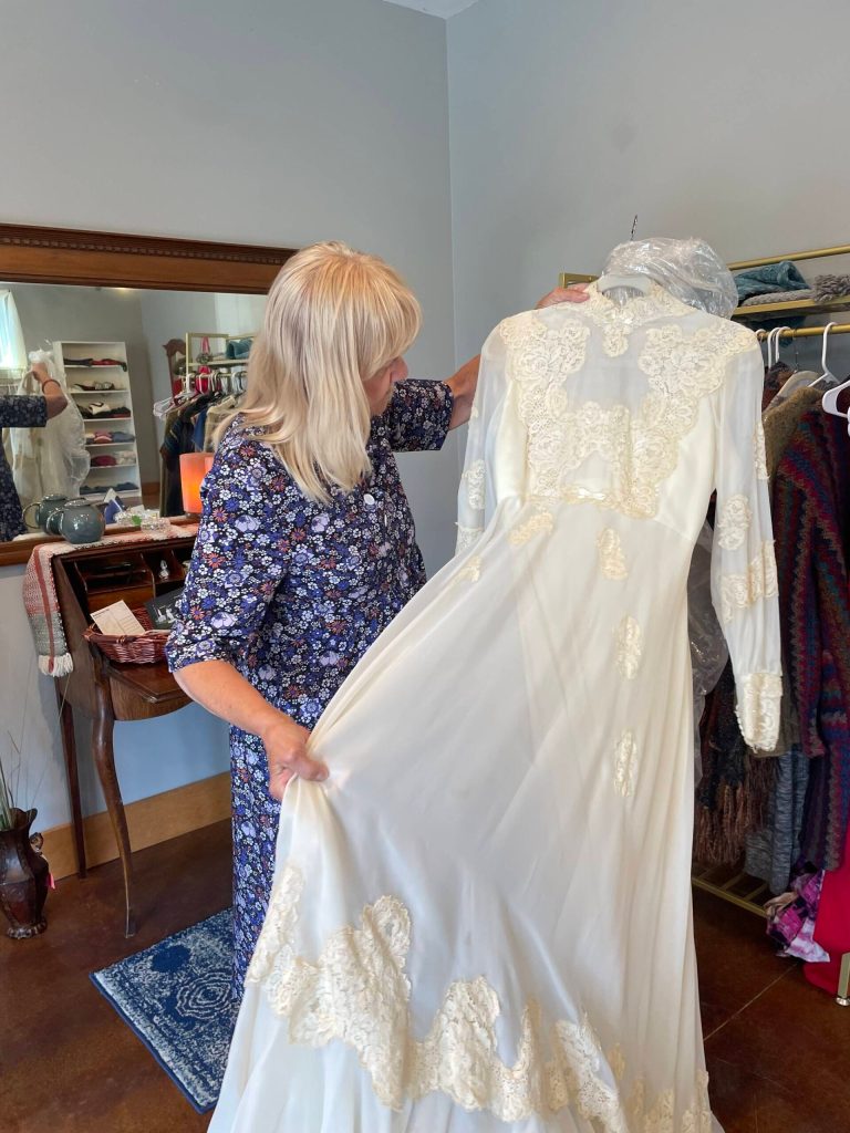 (Photo by Marina Blatt) Parrish holds up her wedding dress for sale.