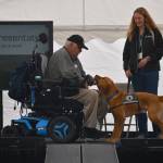 (Photo by Emily Gilbert) Jon Palmason and dog Valko demonstrate how the canine can help with daily tasks  such as picking up dropped reading glasses  to help him live more independently. Summit Assistance Dogs staff trainer, Lindy Langum, right, worked with the pair to train Valko to be an assistance dog.