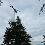 (Photo by South Whidbey Fire/EMS) A Department of Natural Resources helicopter responded to the fire, pouring down water from above.