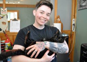 Animal care technician Morgan Kenaley with Shadow at the Freeland Cat Cottage. Photo by Mary Jo Adams.