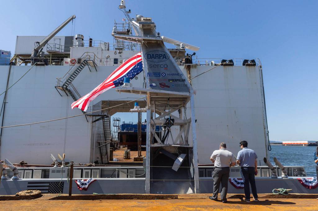 An American flag blows in the wind from the USX-1 Defiant, a first-of-its-kind autonomous naval ship, at Everett Ship Repair on Monday, Aug. 11, 2025 in Everett, Washington. (Olivia Vanni / The Herald)