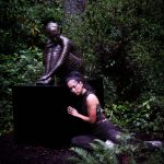 (Photo provided) A dancer poses next to a huddled sculpture of a person.