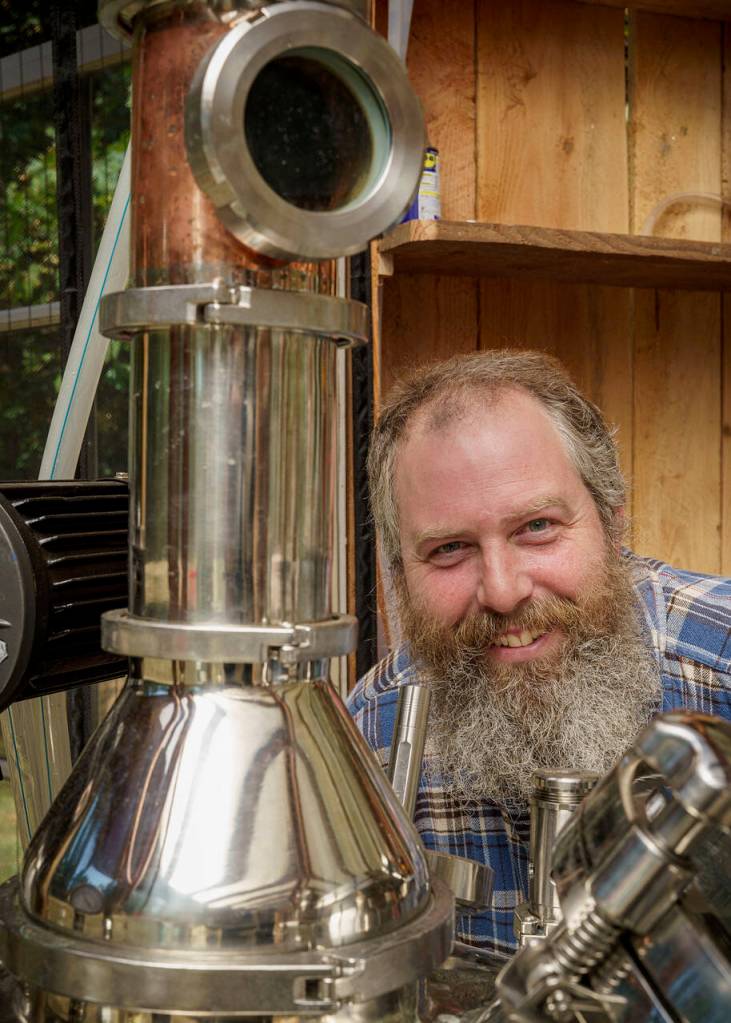 (Photo by David Welton) John Giardina with the shiny still thats responsible for creating Wheyfarer Vodka.