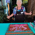 (Photo provided) Debbie Turnbull smiles, ready to cut in to the Clinton Librarys custom, festive anniversary cake.