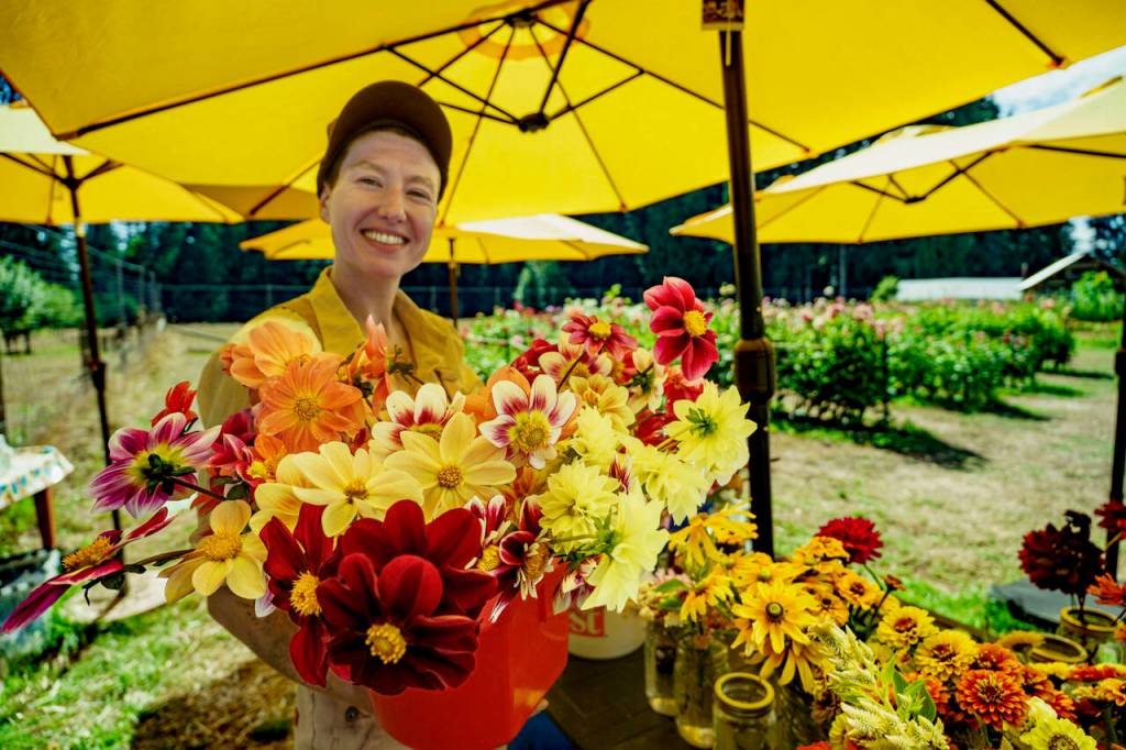 (Photo by David Welton) Dahlia farmer Gabbi Korrow with some vibrant bouquets.