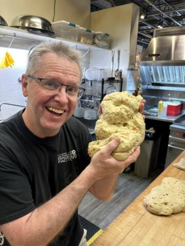 (Photo provided) Clinton Hatton, the soon-to-be new proprietor of the Whidbey Island Bagel Factorys location in Clinton, shapes a Banh Mi dough baby.