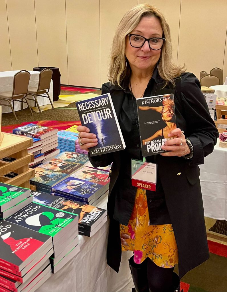 Kim Hornsby surrounded by her books at the Pacific Northwest Writers Association Writers Conference in 2025. (Photo provided)