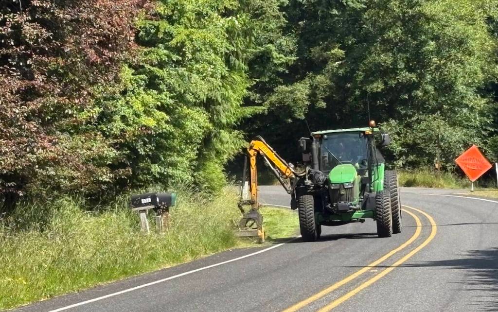 Photo by Laurie Keith
An Island County mowers trims the greenery on the side of a road.