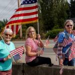 (Photo by David Welton) About 50 people gathered for a Charlie Kirk memorial at the Bayview park and ride on Saturday, bringing numerous American flags to the side of Highway 525. A regularly scheduled demonstration, led by people of differing political viewpoints, occurred at the same time.