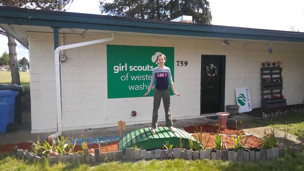 Photo provided
A Girl Scout poses on a mini bridge in front of the Girl Scout House.