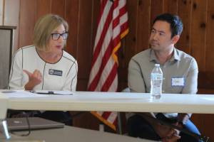 Oak Harbor board President Lynn Goebel speaks on a panel as state Rep. Clyde Shavers listens attentively. (Photo by Marina Blatt)
