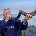 (Photo by David Welton) John Garber blows the shofar, a rams horn, at Glendale Beach.