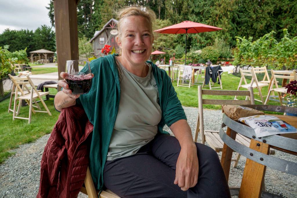 A volunteer sips wine from Spoiled Dog Winery, taking a much-needed break from picking grapes. (Photo by David Welton)